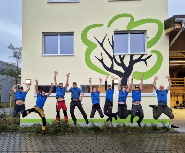 Das ganze Team von Wick Baumpflege jubelnd im Sprung.